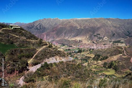 Landscape composed of a house on the mountain to the left, highway below and mountains in the background