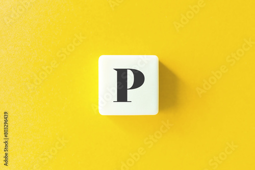 Capital Letter P. Text on Block Letter Tiles against Yellow Background.