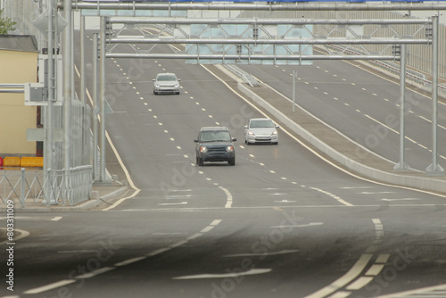 three cars driving off a six-lane highway bridge