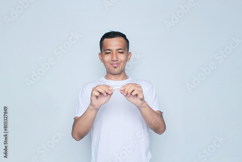 Asian young man wearing a white t-shirt cuts a cigarette in commemoration of world no tobacco day.
