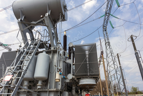 High voltage transformer against a blue sky background. Electric current redistribution substation