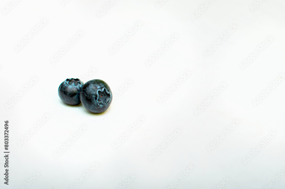 Imagen a detalle horizontal de dos moras azules en un fondo blanco aislado Imagen a detalle horizontal de dos moras azules en un fondo blanco aislado