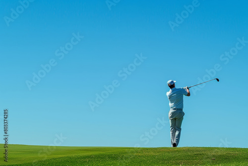 Rear view of man playing golf against clear blue sky
