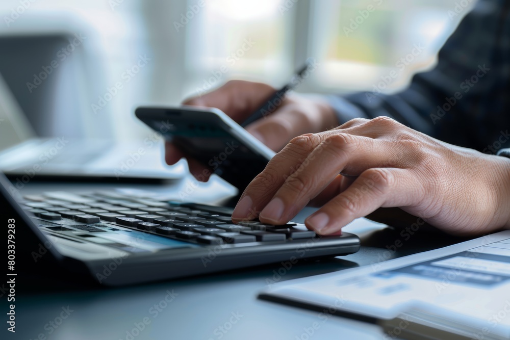 Person Typing on Laptop With Calculator Person Typing on Laptop With Calculator