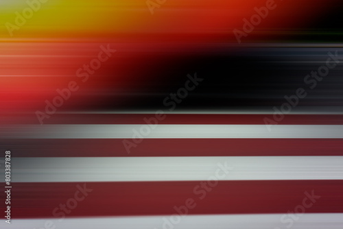 Abstract blurred background, horizontal black, orange, white, red stripes.