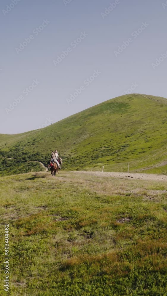 Two girls enjoy a horseback ride through the verdant landscapes of the Carpathian Mountains. Two girls enjoy a horseback ride through the verdant landscapes of the Carpathian Mountains.
