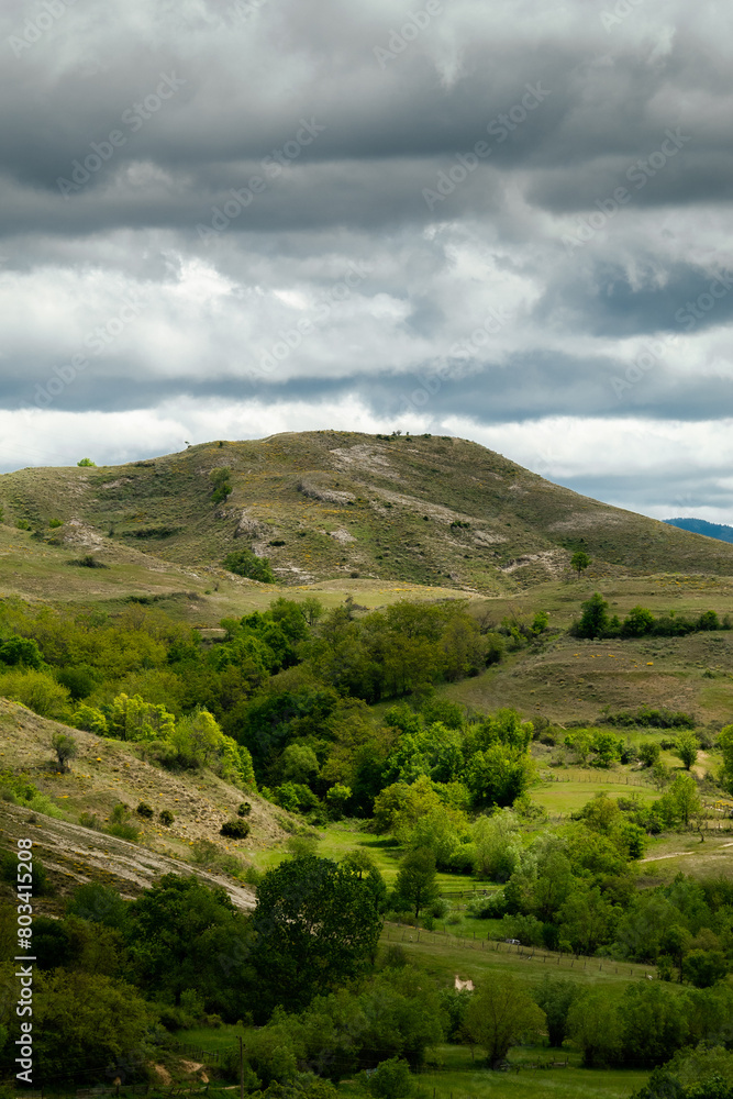 Obraz premium Meadows with beautiful hills and cloudy sky.