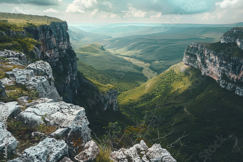 A breathtaking view of a lush valley seen from the top of a rocky cliff photo