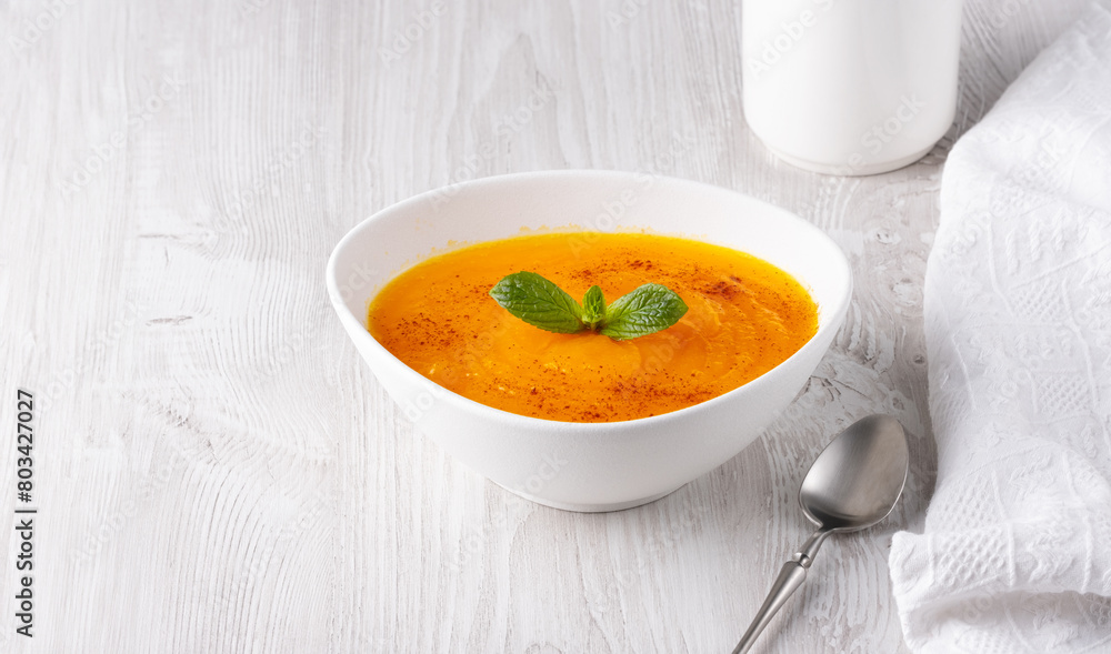 Pumpkin soup on a white wooden table, with copy space for text Pumpkin soup on a white wooden table, with copy space for text