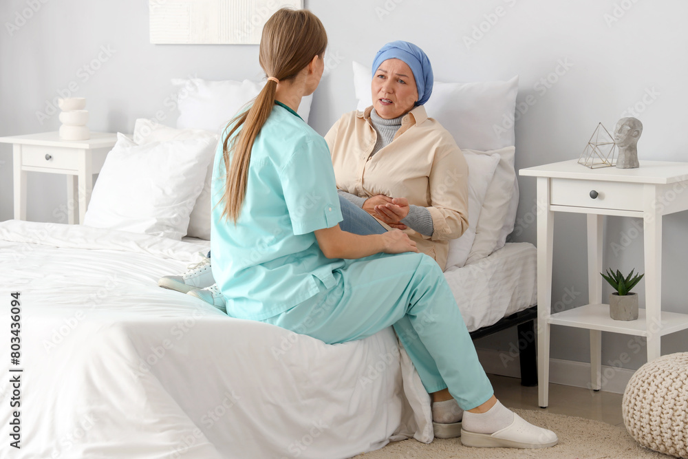 Obraz premium Mature woman after chemotherapy with nurse in bedroom. Stomach cancer concept