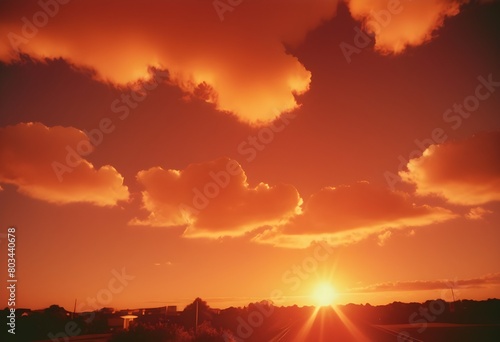 Dramatic Sunset with Sun Rays Breaking Through Clouds Over Orange and Purple Sky