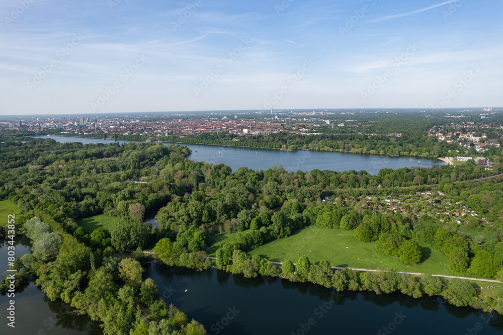 A lake nestled amidst trees and grass viewed from the sky Hanover Ricklinger Teiche Germany