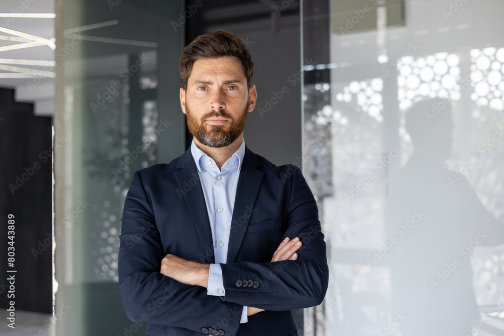 Confident businessman standing in a modern office setting Confident businessman standing in a modern office setting