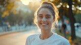 Happy smiling young woman in a white T-shirt going for morning jog
