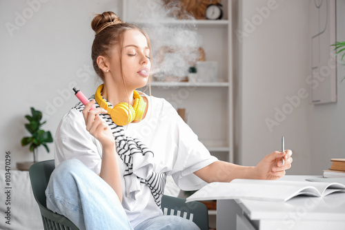 Young woman smoking disposa...