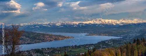 Panoramic view of Zurich lake and the snow-capped Swiss Alps from the top of Uetliberg mountain at sunset time