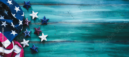 Colorful Fourth of July Background. American flag and red, white and blue stars over a rustic wood table for Independence Day celebration. Banner with copy space. 