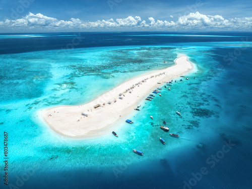 Aerial view of Nakupenda island, sandbank in ocean, white sand, boats, yachts, blue sea during low tide at sunny summer day in Zanzibar. Top view of sand spit, clear water, sky with clouds. Tropical photo