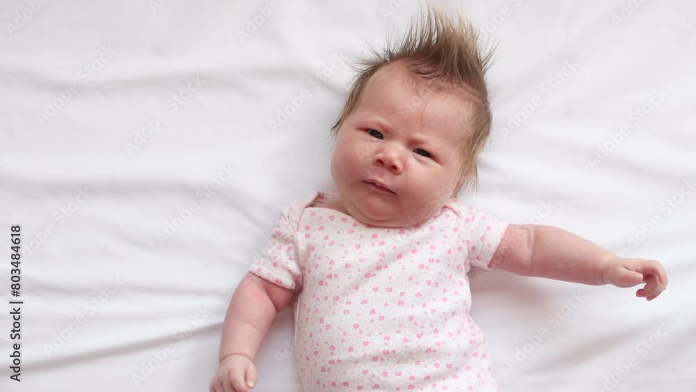 4K video of Cute Caucasian newborn baby girl making funny face expressions. 5 week old baby girl on a white background 4K video of Cute Caucasian newborn baby girl making funny face expressions. 5 week old baby girl on a white background
