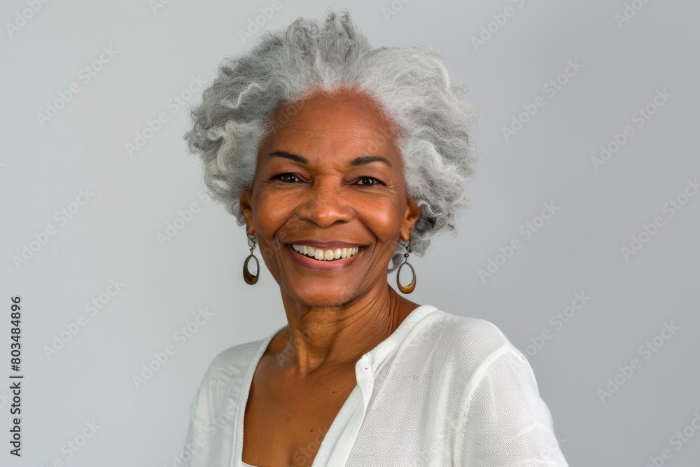 A mature woman with a delightful smile and white hair, projecting warmth and confidence in her portrait
