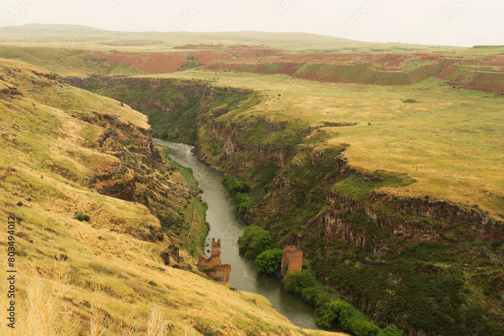 Naklejka premium The destroyed, ruined bridge that was built over the Akhurian River down in the canyon, gorge that now forms the border between Turkey and Armenia at the ancient site of Ani, Kars, Turkey