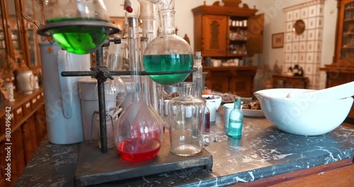 Chemistry beakers, bottles and flasks with colorful liquids, medicinal herbs, mortar for grinding herbs on the table in an old pharmacy. Cinema 4K 60fps video photo