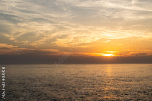 Landscape photo of dramatic, steep orange cliffs by the atlantic at sunset. Shot in Farol fo Cabo de Sao Vincente near Sagres, Portugal. © Ekaterina