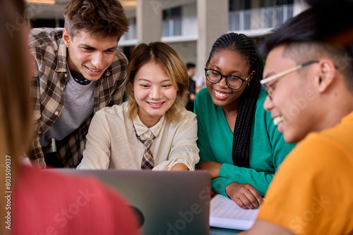Group of diverse multiethnic smiling young students using laptop studying gathering in classroom. Academics multiracial people classmates working in a project creative inside of university building photo