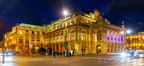 Photography Scenic view of busy night central avenue of Vienna and impressive illuminated building of famous State Opera in winter, Austria