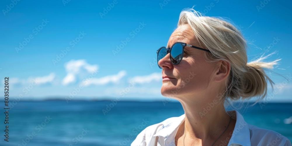 Joyful woman basks in vibrant summer sunshine against deep blue ocean backdrop, sunglasses reflecting clear skies, epitomizing freedom and vacation vibes. Copy space. Joyful woman basks in vibrant summer sunshine against deep blue ocean backdrop, sunglasses reflecting clear skies, epitomizing freedom and vacation vibes. Copy space.