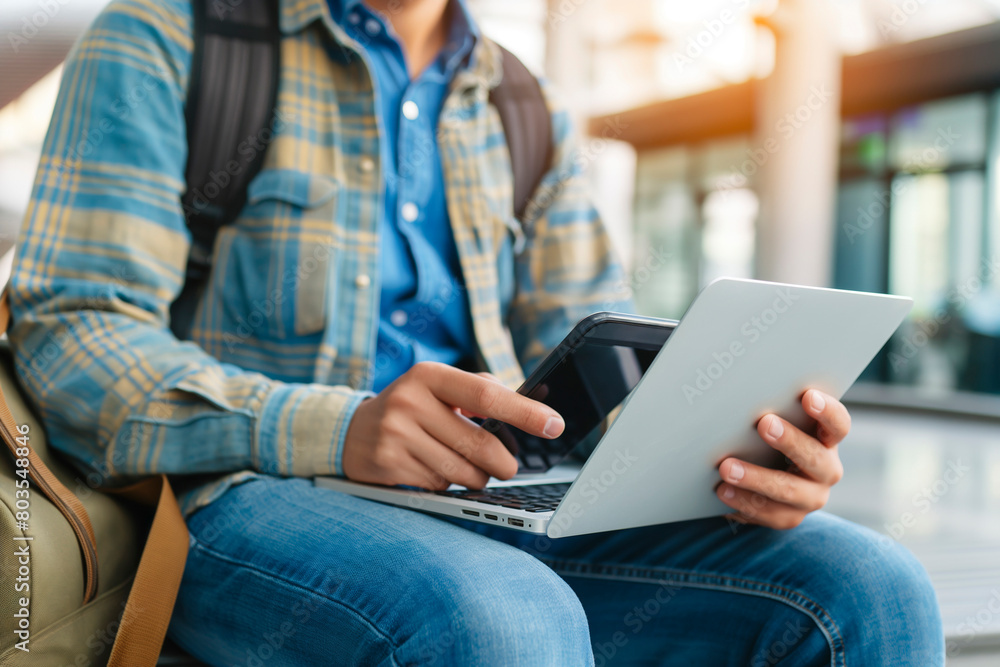 Man using a laptop and smartphone for booking hotel online. Tour reservation, Booking online concept Man using a laptop and smartphone for booking hotel online. Tour reservation, Booking online concept