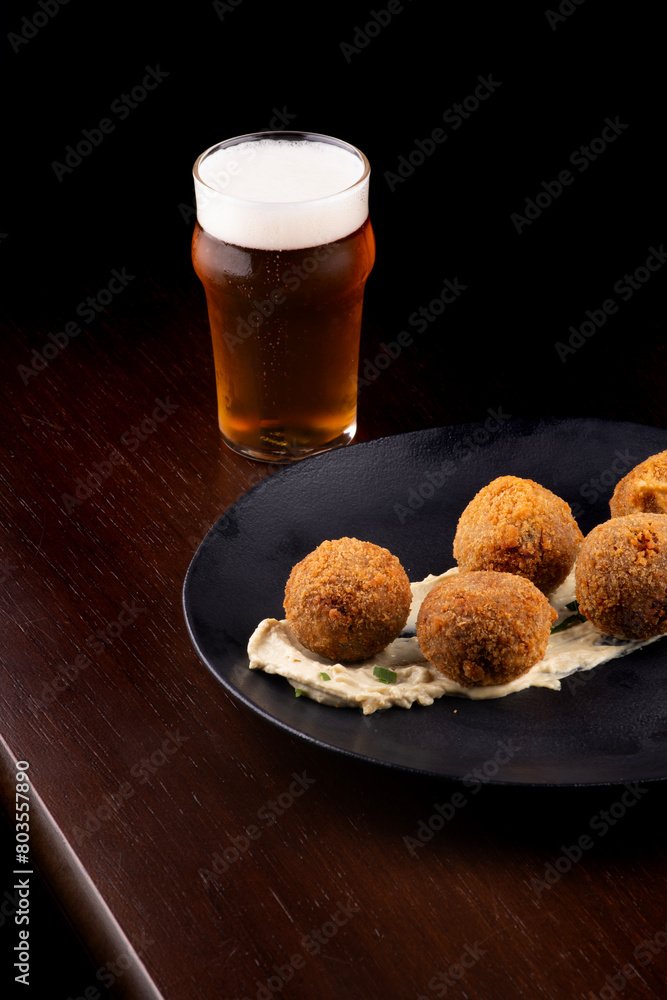 fried fish cake appetizer salmon cod with half pint of craft beer on wooden table fried fish cake appetizer salmon cod with half pint of craft beer on wooden table
