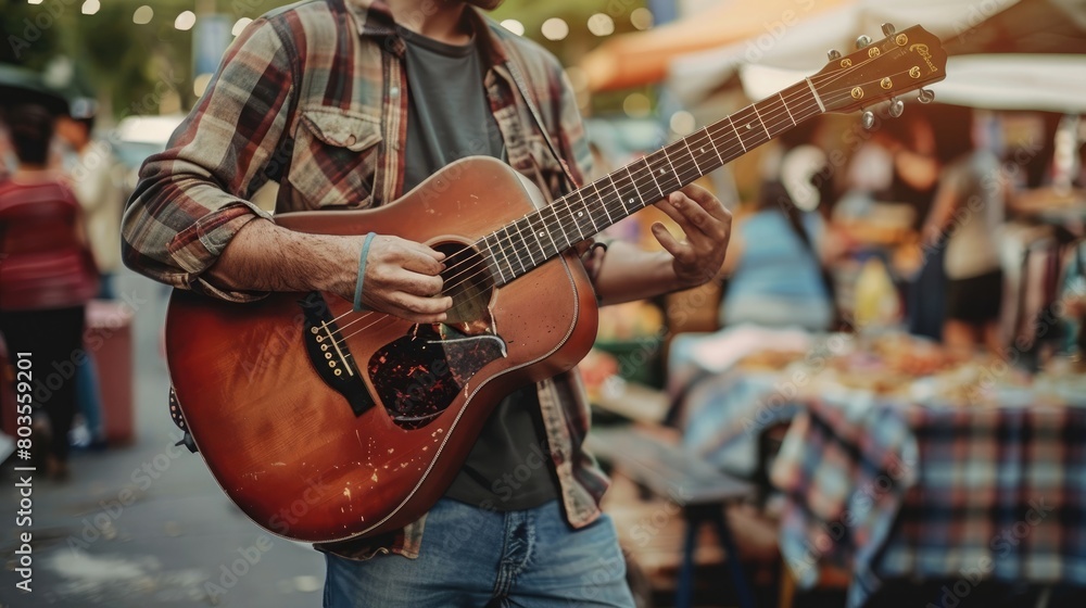 Musician playing a guitar in the middle of a summer market