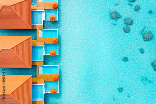 Top down view on villas on the tropical beach with steps into water. Beautiful beach with clear blue water and sunny water bungalows