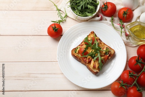 Tasty pizza toasts and ingredients on light wooden table, flat lay. Space for text