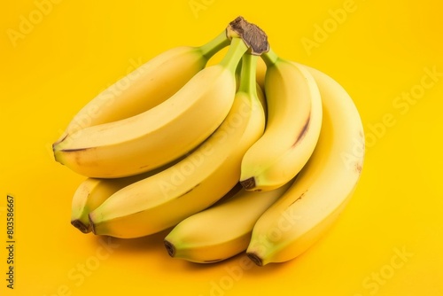 A highresolution stock photo of a bunch of fresh bananas on a bright yellow background, demonstrating the texture and natural shine of the fruit, perfect for food and nutrition themes