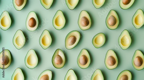 Multiple Avocados Cut in Half on a Green Background photo
