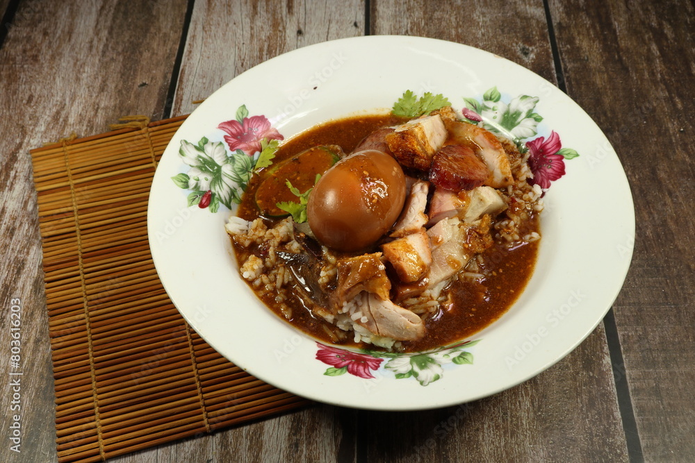 Local crispy pork and boiled egg topping on cooked rice and dressing with gravy sauce. Famous street food menu in Chinese restaurant. Local crispy pork and boiled egg topping on cooked rice and dressing with gravy sauce. Famous street food menu in Chinese restaurant.