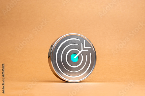 Target dart icon on circle chrome badge on brown recycled paper background, minimal style. Business strategy, action plan and future innovation technology with goal and success concepts.