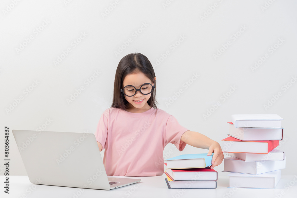 a student on the table and laptop among a large number of books a student on the table and laptop among a large number of books