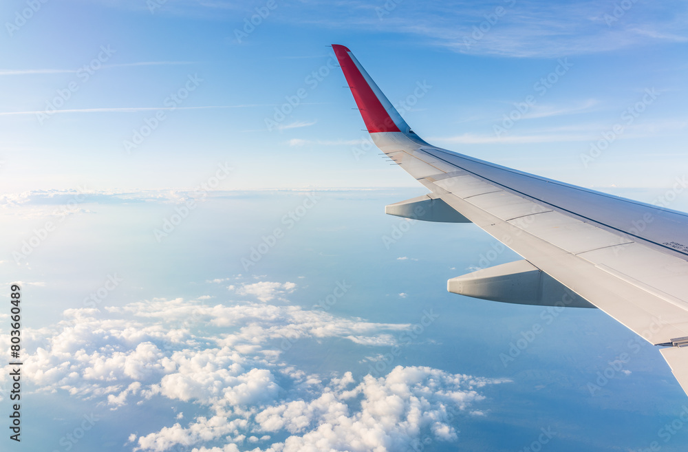 View from the airplane window at a beautiful cloudy sky and the airplane wing