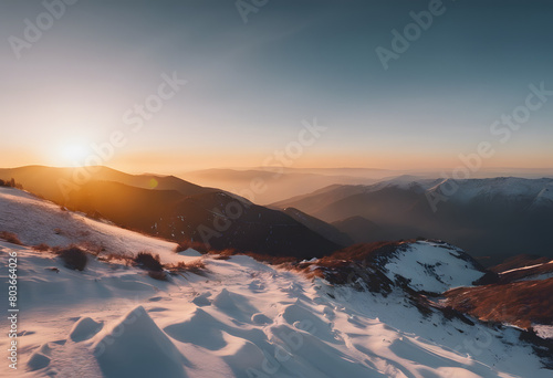 Sunrise over snow-covered mountains with clear skies and soft light illuminating the landscape. Mountain Day.
