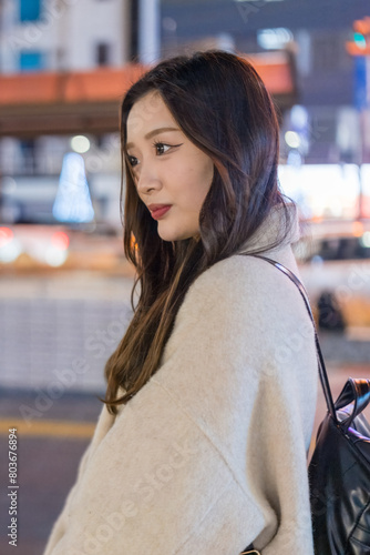 A Chinese woman in her 20s taking a walk at night in front of the station in Omiya Ward, Saitama City, Saitama Prefecture 埼玉県さいたま市大宮区の駅前を夜に散歩する２０代の中国人女性 photo