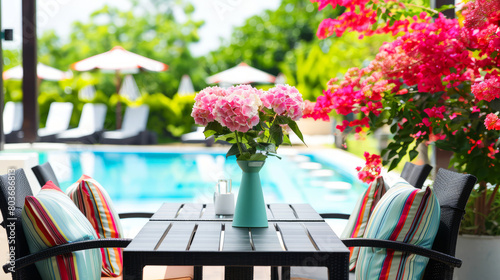 Vibrant outdoor poolside setting with a vase of pink hydrangeas on a table  surrounded by lush tropical flora