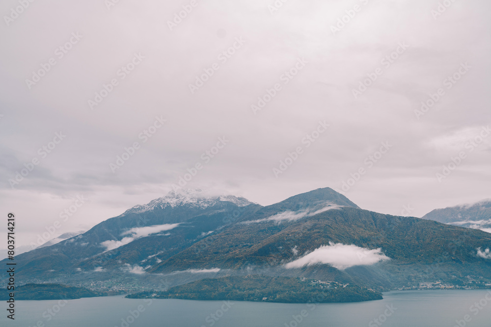 Misty forested mountain range on the shore of Lake Como. Italy