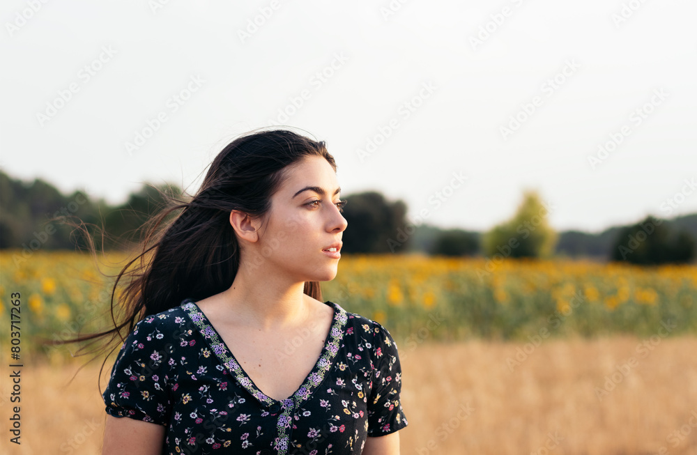 Portrait of a pretty young woman with long hair in the countryside