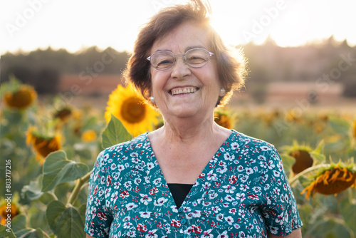 Elderly woman in a field of sunflowers