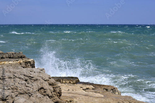 onde del mare si infangono sugli scogli della spiaggia di polignano a mare in puglia