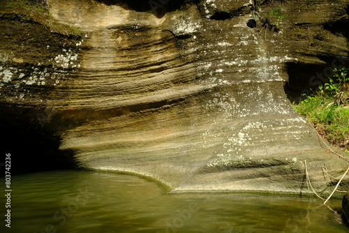 river banks with layered sedimentary rocks. Sedimentary rock, is a type of rock formed by sedimentation and cementation that can occur on the earth's surface and underground or in water. batu sedimen. photo