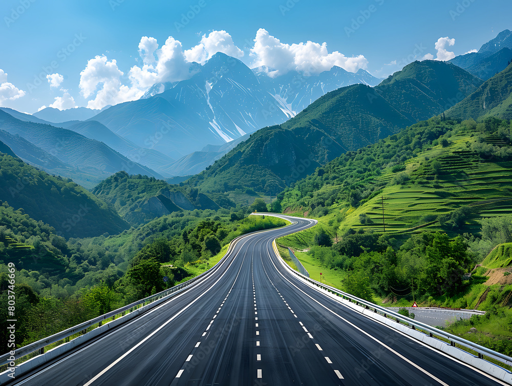 Fototapeta premium A long, empty highway winds through a valley between mountains.